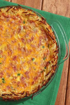 a cheesy casserole is sitting on a green napkin