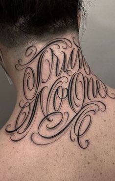 the back of a man's neck with his name tattooed on it, in black ink