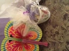 a table topped with paper plates and bags filled with candy next to an umbrella shaped fan