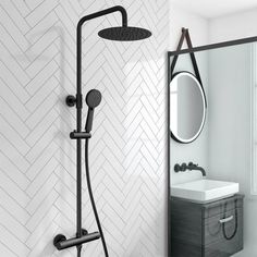 a bathroom with a sink, mirror and shower head in black color on the wall