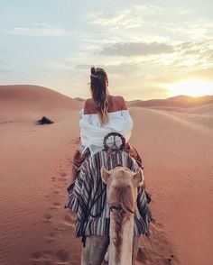 a woman riding on the back of a camel