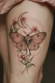 a woman's thigh with a butterfly and flower tattoo on it