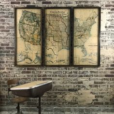 three framed maps on a brick wall in an industrial style room with a metal chair