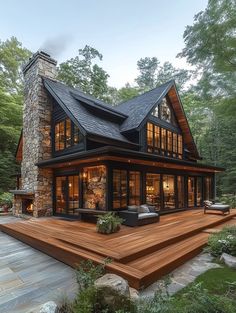 a large wooden deck in front of a stone and wood house with an outdoor fireplace