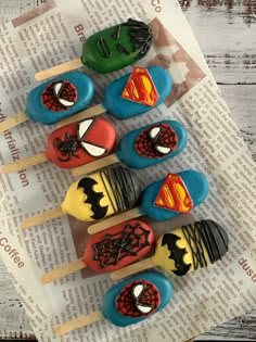 there are many cupcakes that have been decorated to look like superman and spiderman