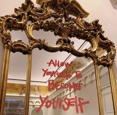 an ornate gold mirror with the words always yourself to become yourself written in red on it