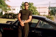 a man standing in front of a black car