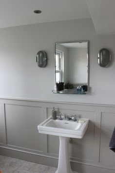 a white pedestal sink sitting under a mirror