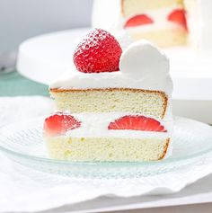 a piece of cake with white frosting and strawberries on top is sitting on a plate