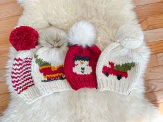 a white teddy bear with two knitted hats on it's back and one is wearing a santa hat