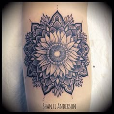 a black and white photo of a sunflower tattoo on the right side of the thigh