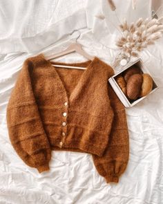 a brown sweater and some rocks on a bed