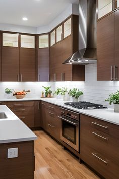 a kitchen with wooden cabinets and white counter tops, along with a stainless steel range hood