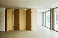 an empty room with wooden partitions in the middle and large windows on either side