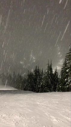 a man riding skis on top of a snow covered slope under a cloudy sky