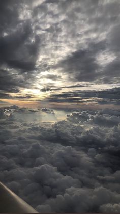 the view from an airplane looking down on clouds and sun shining through it's window