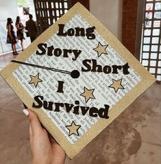 someone holding up a graduation cap that says long story short i survived