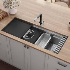 a kitchen sink with an open drawer in the middle and a cutting board on the counter