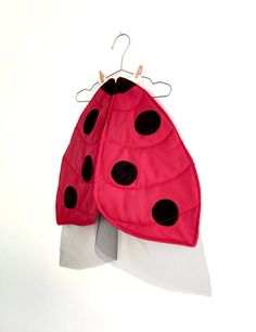 a pink and black lady bug hanging on a white wall