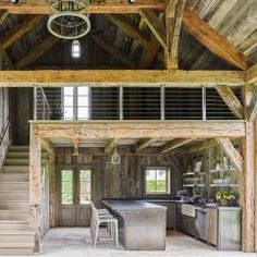 the inside of a large wooden building with stairs leading up to an open floor plan