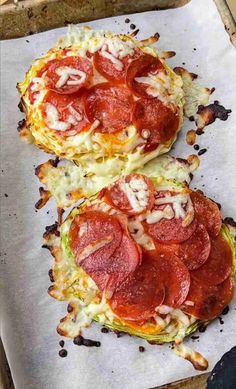 two pizzas with pepperoni and cheese are on a baking sheet, ready to go into the oven