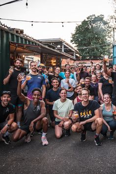 a group of people are posing for a photo with beer glasses in their hands and smiling