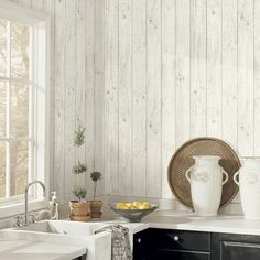 a kitchen with white walls and wooden paneling on the wall is pictured in this image