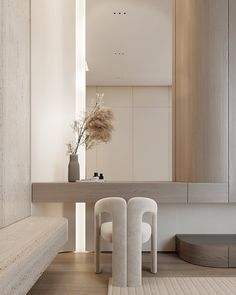 two white chairs sitting in front of a table with a vase on top of it