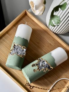 two candles sitting on top of a wooden tray