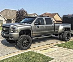 a silver truck parked in front of a house