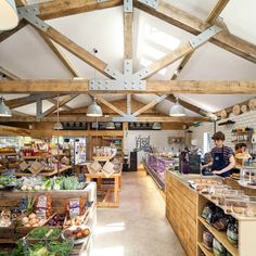 the inside of a store with lots of food on shelves and people working in it