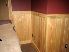 a bed in a room with wood paneling on the walls