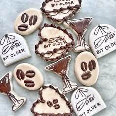 decorated cookies with chocolate and white frosting are on a blue tablecloth, next to the words bit older