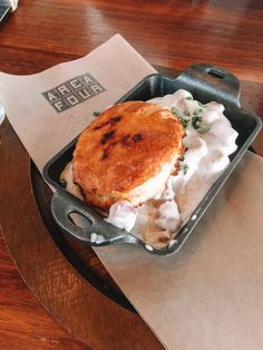 a pan filled with food sitting on top of a table next to a paper napkin