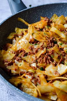 an iron skillet filled with pasta and meat