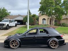 a black car parked in front of a house