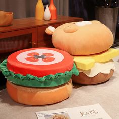 two hamburgers sitting on top of each other in front of a table with magazines