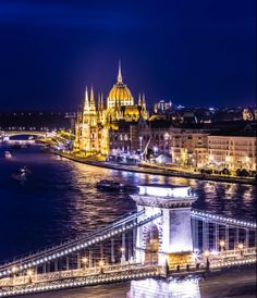 the bridge is lit up at night and has many lights on it's sides