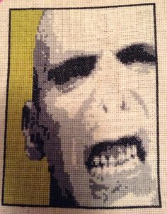 a close up of a cross stitch picture of a man's face with teeth