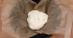 a piece of bread sitting in a brown paper bag on top of a black plate