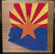 a piece of art made to look like the state of arizona, on a wooden surface