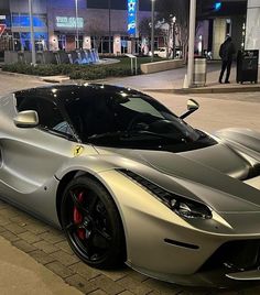 a silver sports car parked in front of a building