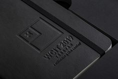 a close up of a black book with a logo on the front and back cover