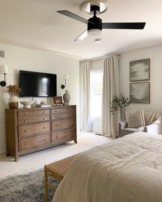 a bed room with a neatly made bed and a flat screen tv on the wall