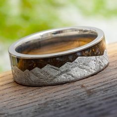 Meteorite mountain ring with dinosaur bone on wood Meteorite Wedding Band, Gibeon Meteorite, Alternative Wedding Bands, Meteorite Jewelry, Mountain Ring, Flat Ring, Bone Ring, Mountain Design, Engraving Fonts