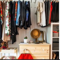 a closet with clothes hanging on the wall and a purse sitting on top of it