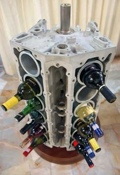 a wine rack made out of an old car engine with bottles in it and the words how to convince the wife to decorate with car parts