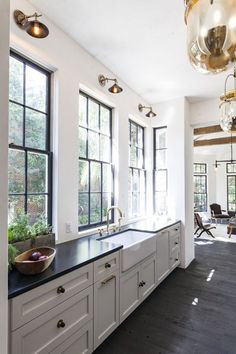 a large kitchen with white cabinets and black counter tops, along with an island in the middle