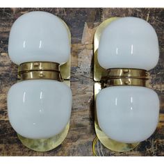 two white glass and brass wall sconces