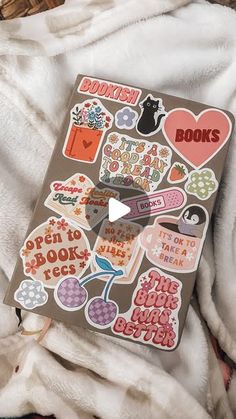 a book with lots of stickers on it sitting on top of a white blanket